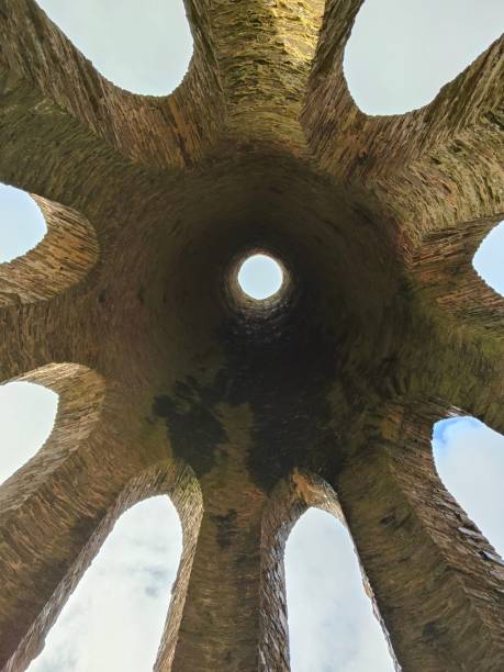 istock Low angle view of an ancient structure with sunlight coming through a round hole on its roof 1456090082