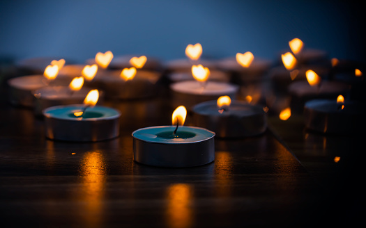Group of flickering candlelight on wooden table in dark room blurred  background. Relaxing and yoga concept.