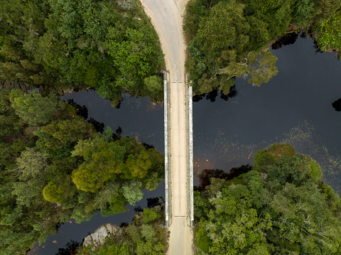 Aerial view of a bridge crossing a river in a lush forest. Old bridges along the 7 passes route on the Garden Route in South Africa.