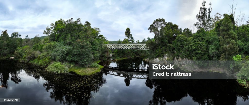 Old bridge crossing a beautiful river Aerial view of a bridge crossing a river in a lush forest. Old bridges along the 7 passes route on the Garden Route in South Africa. Above Stock Photo