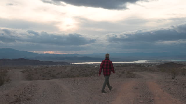 Mature man explores desert are under ominous sky