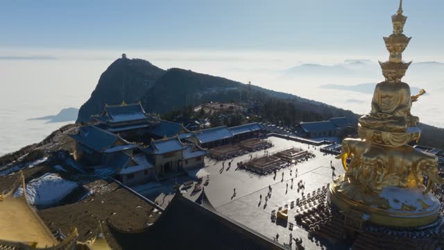 Golden summit of Mount Emei in sunny winter day with tourist travel sea of clouds Sichuan China