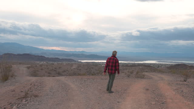 Mature man explores desert are under ominous sky