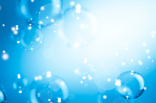 Beautiful Blurred Shiny Blue Bubbles Abstract Background. Defocused Dust and Stars Space. White Bokeh Magic. Celebration Festive Christmas Holiday Backdrop.