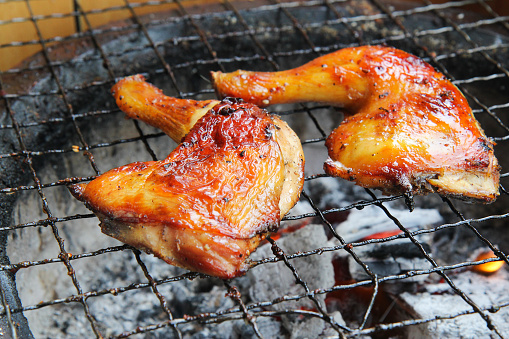 Grilled chicken thighs on the charcoal grill, top view, close up