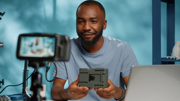 istock Influencer reviewing v mount power battery on camera 1456103172