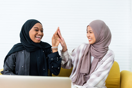 Two young woman Muslim showing traditional Muslim greeting
