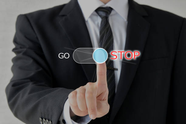 Business man pushing button with STOP word