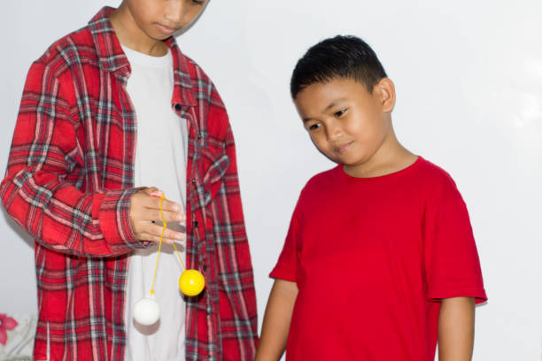 boy play the Lato-lato game which is a type of traditional game that is commonly found in Indonesia