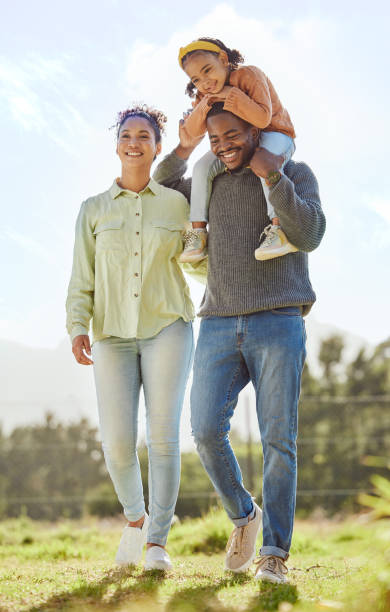 schwarze familie, vater tragen mädchen und draußen für qualität zeit, glücklich und lächeln zusammen im freien. eltern, mama und papa mit tochter gehen, sich verbinden und lieben für glück, pause und spaß. - play time stock-fotos und bilder