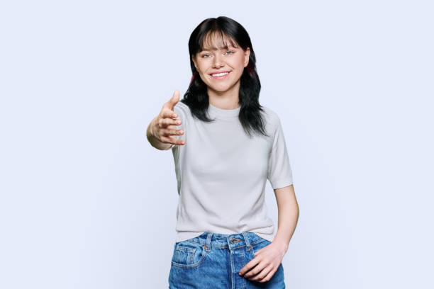 istock Young teenage female student shaking hands, over white background 1456112200
