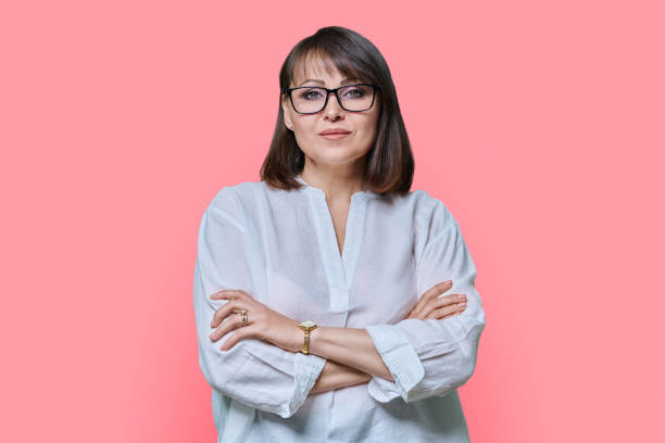 istock Serious confident middle aged woman on pink background 1456112298
