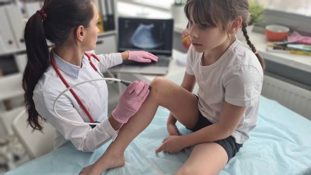 Patient is child with orthopedic doctor ultrasound of knee Patient is child with orthopedic doctor ultrasound of knee. Ultrasound of knee joints and arthritis arthritis stock pictures, royalty-free photos & images