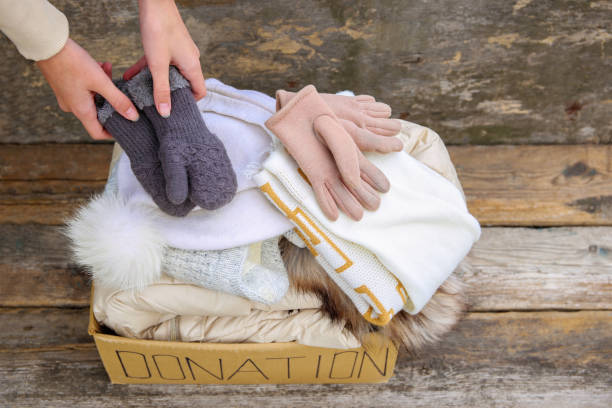 istock Donation box with winter clothes on an old wooden background. 1456115833