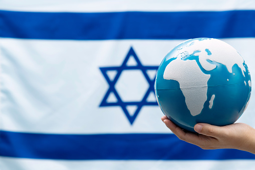 World globe in front of Israeli flag.