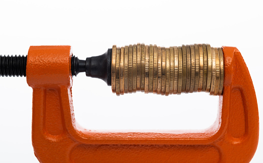 Orange clamp with stack of coins.