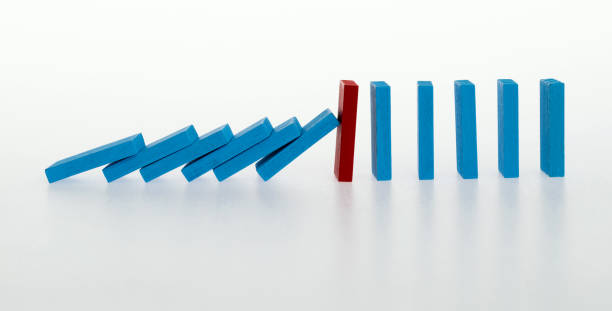 istock Red wooden block stop other falling dominos 1456117680