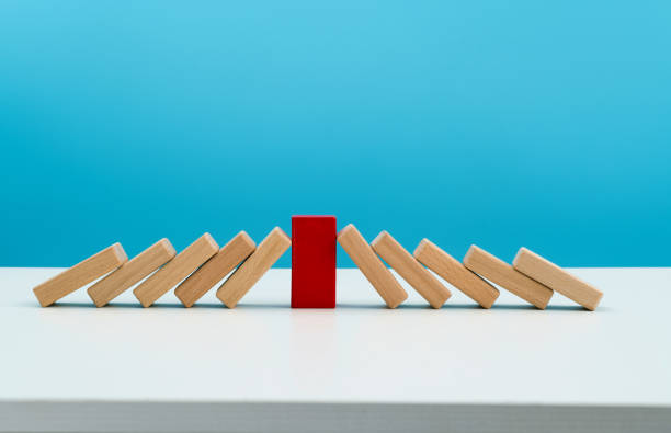 istock Red wooden block stop other falling dominos 1456117710
