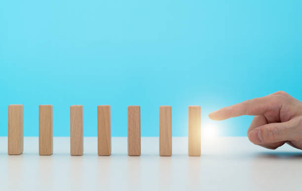 istock Human finger pushing domino pieces 1456117712