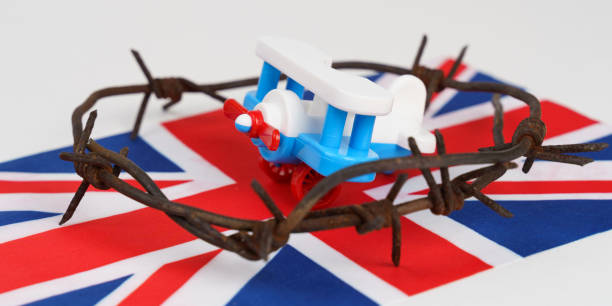 istock Toy plane, UK flag and barbed wire on a white background. 1456118465