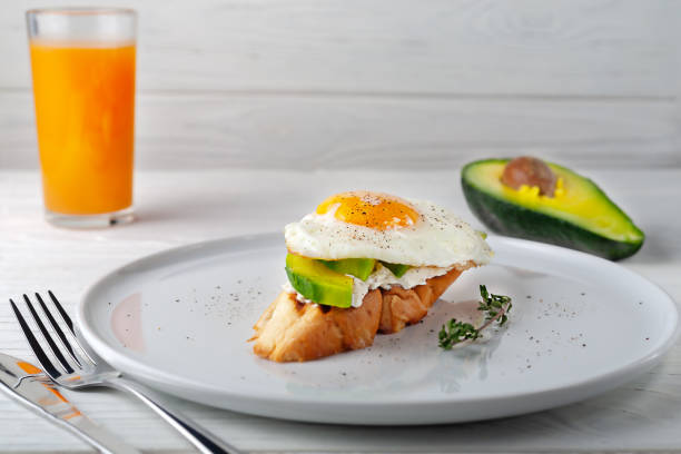 Delicious toast with avocado, melted cheese and scrambled eggs