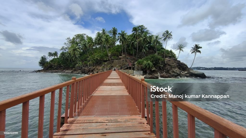 View of an isalnd The bridge leading to the mystical island surrounded by palm trees and blue ocean Backgrounds Stock Photo