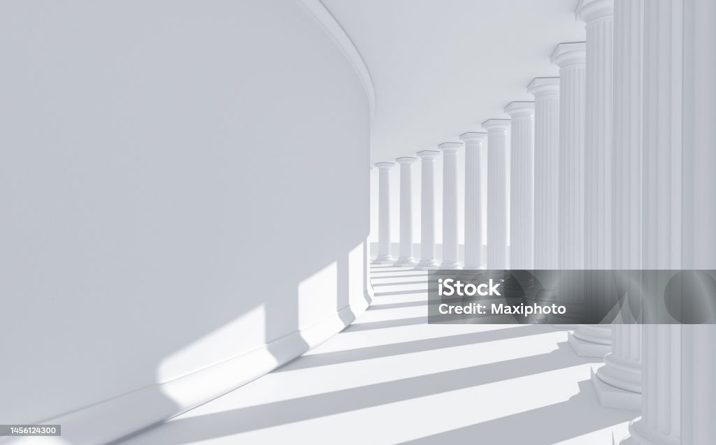 White columns in a bent row: classical roman and greek architecture with copy space. Abstract building with a bent row of white columns casting shadows on a curved wall. Abstract architecture resembling a government building dedicated to law, justice and education: strength, stability and order. Digital image with copy space on left side. Law Stock Photo