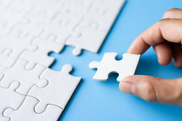 hand put the last piece of jigsaw puzzle to complete the mission, business solutions, success and strategy concept - jigsaw puzzle solution one person people imagens e fotografias de stock