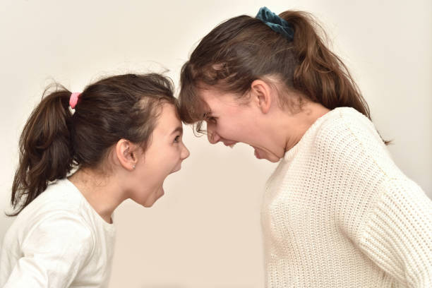 istock Two angry sisters standing face to face and quarreling 1456129180