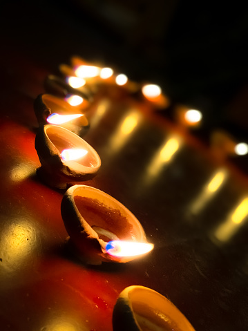 A vertical closeup of the circle of candles burning in the darkness.