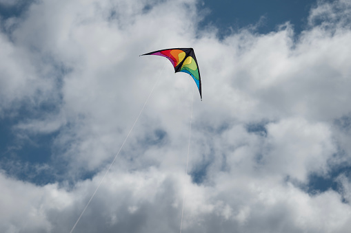 A view of a lonesome colorful kite with clouds in the background