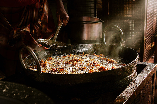 A closeup shot of pot with Indian food during the frying process