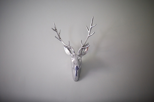 A decorative head of a deer on a white wall