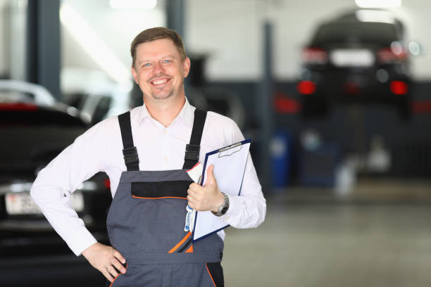 sorridente jovem mecânico de automóveis aceitando um carro em reparo - car workshop service expertise - fotografias e filmes do acervo