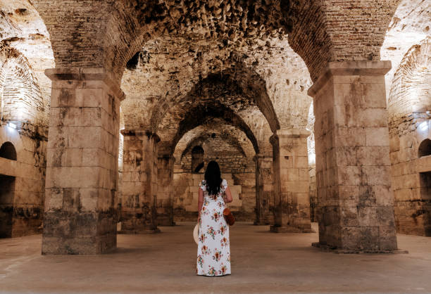 vue arrière d’une jeune femme debout dans la salle souterraine du palais de dioclétien, croatie - diocletian photos et images de collection