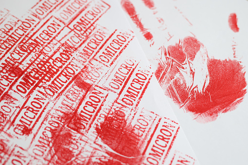 Lots of red stamps stamped with omicron background closeup. Coronavirus infection and medical diagnosis concept