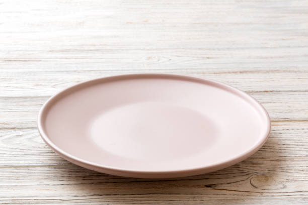 istock Perspective view of empty pink plate on wooden background. Empty space for your design 1456135136