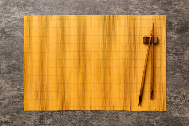 istock Two chopsticks and bamboo mat on cement background. Top view, copy space 1456135166