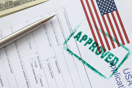 USA visa approved rubber stamp and application form. Assistance in obtaining and processing visas to USA concept