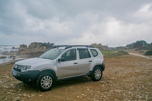 Side, Antalya, Turkey-January 11, 2023: Silver gray  duster is parked on the beach on a stormy day at Side, Antalya, Turkey