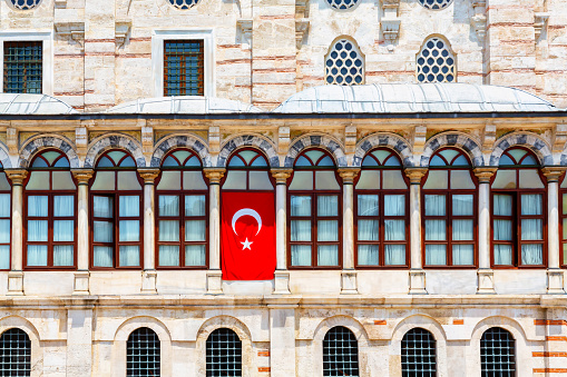 Istanbul, Turkey (Turkiye). Laleli Mosque (Tulip mosque). An 18th century Ottoman imperial mosque located in Laleli, Fatih. Close up shot of the windows row with national turkish flag at one window