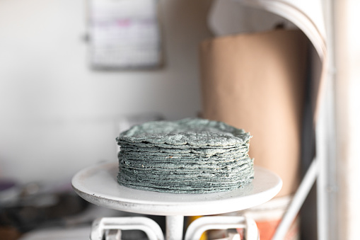 One kilo of blue corn tortillas are on the weighing scale. Concept of traditional corn tortillas preparation