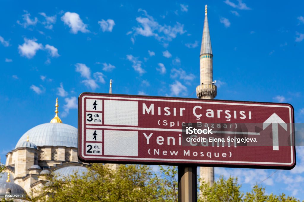 Road sign Spice Bazaar or Misir Carsisi in Turkish, also New Mosque or Yeni Camii in Turkish. Defocused New mosque dome at background. Historical centers of Istanbul, Turkey (Turkiye) Aegean Turkey Stock Photo