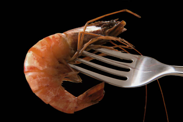 istock Closeup shot of a shrimp on a fork against a black background 1456141061