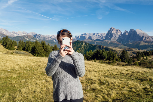 Young teenage girl taking selfie with mountains. Photo taken in Dolomites / Italy