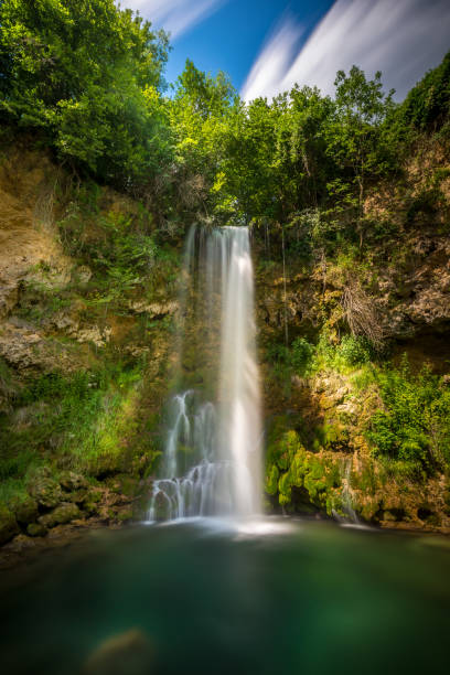 istock Vertical shot of a beautiful waterfall coming from a forest 1456142320