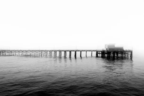 Photo of Grayscale view of a peaceful pier at Newport Beach in California, USA