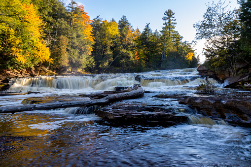 A landscape of the Bond Falls with long exposure in a forest in autumn in Michigan, the US