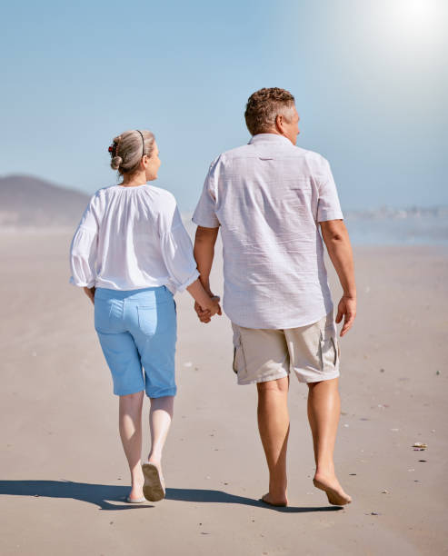 istock Beach, summer and senior couple walking for exercise while on vacation, adventure or journey. Love, holding hands and elderly man and woman pensioners on walk while on retirement holiday in Australia 1456144068
