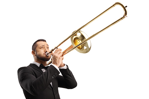 Elegant young man playing a trombone isolated on white background